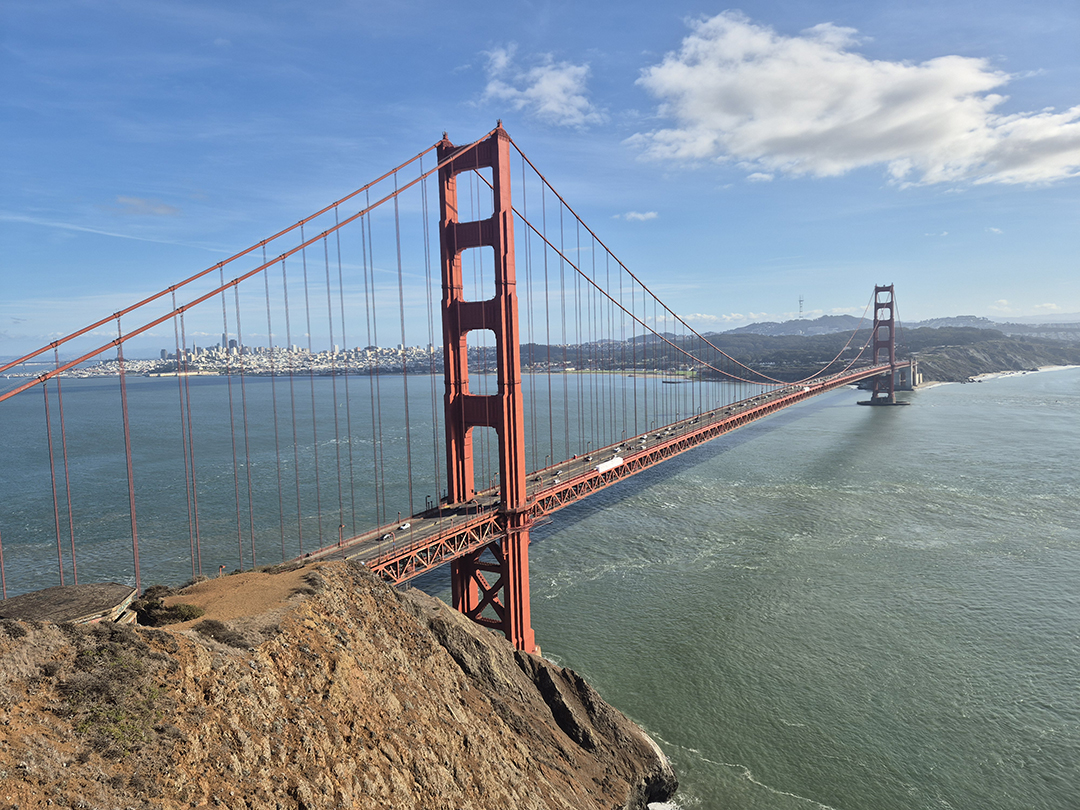 The iconic Golden Gate Bridge stretching across the entrance to San Francisco Bay with a panoramic city view.