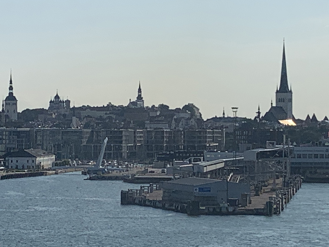View of Tallinn’s harbor with its iconic church spires and the medieval old town rising above the Baltic Sea.