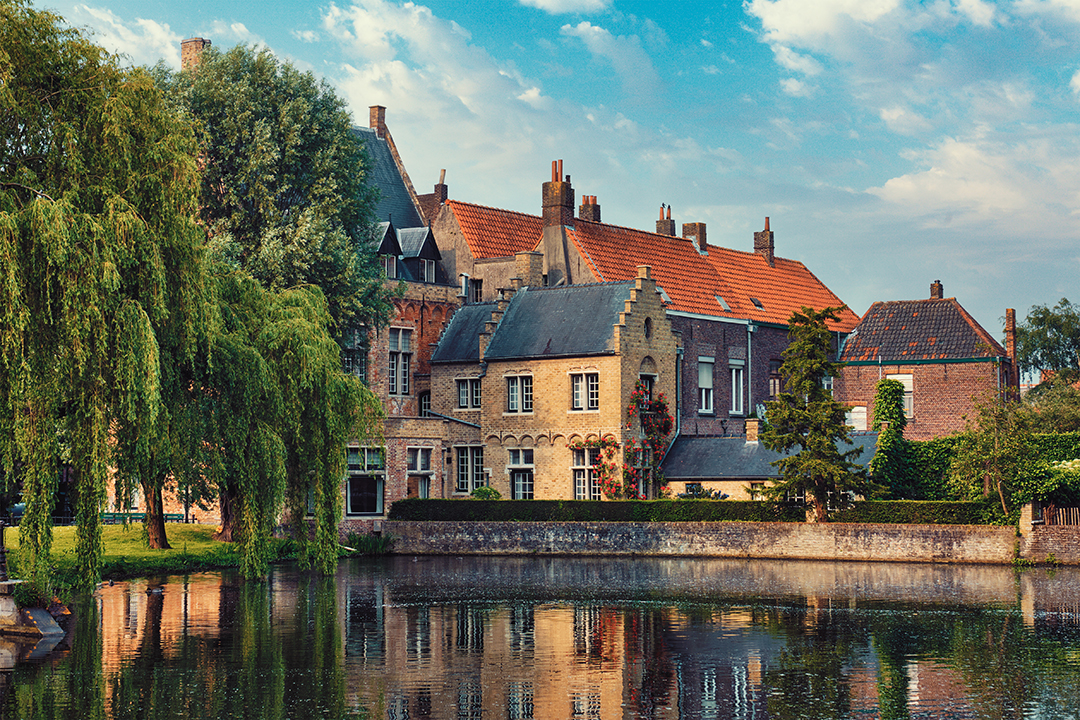 Historic Flemish houses along a canal in Bruges, one of the most romantic cities in Belgium.