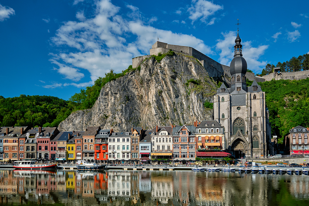 Dinant town along the Meuse River with Notre Dame church and the citadel on the cliff.