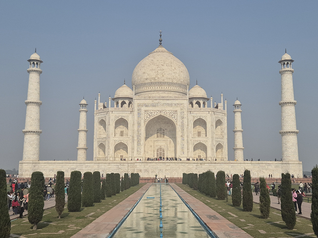 Taj Mahal in Agra India with the famous garden and reflecting water channel leading to the white marble mausoleum, one of the New Seven Wonders of the World.