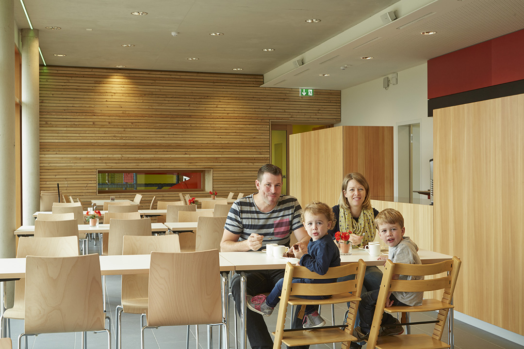 Family in the dining area of a youth hostel in Beaufort, welcoming space for family travel and shared meals.