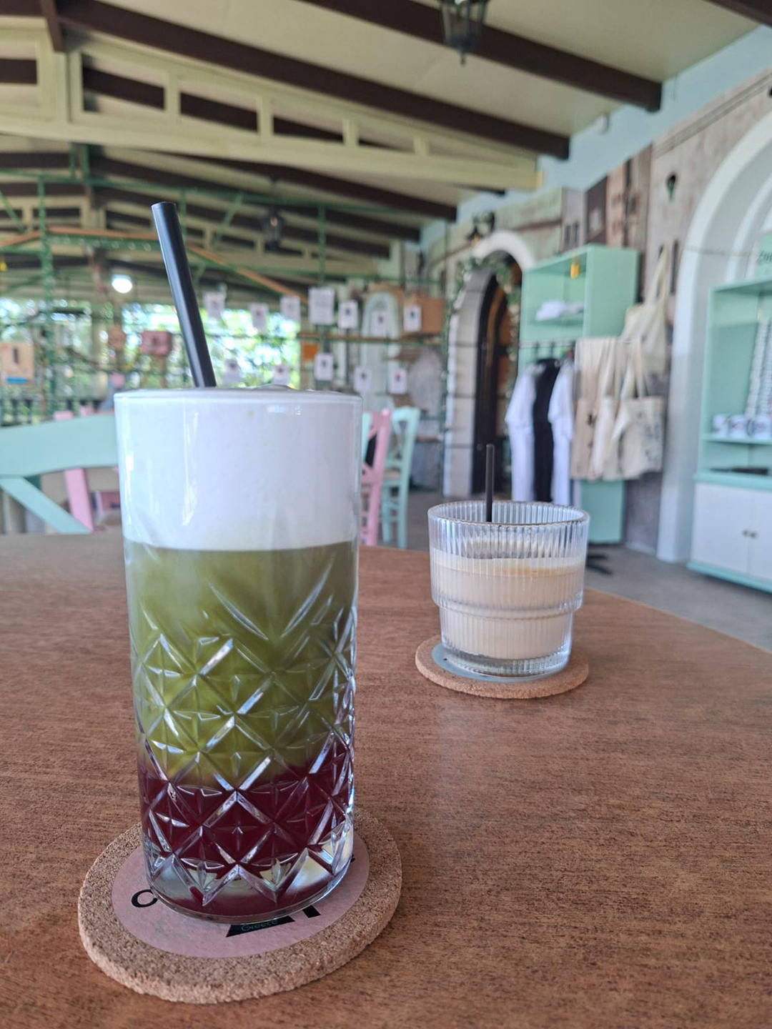 Matcha napitek in kava v Cat Cafe Zepos Garden na Zakintosu, kjer obiskovalci z nakupom hrane in pijače pomagajo financirati oskrbo ter posvojitve mačk.
