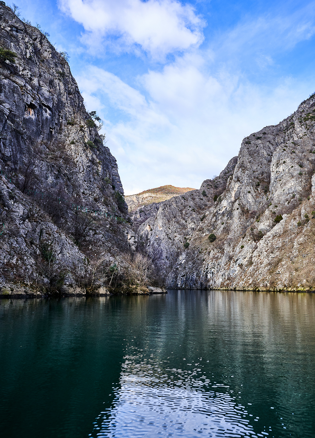 Turquoise lake surrounded by high cliffs in Matka Canyon near Skopje