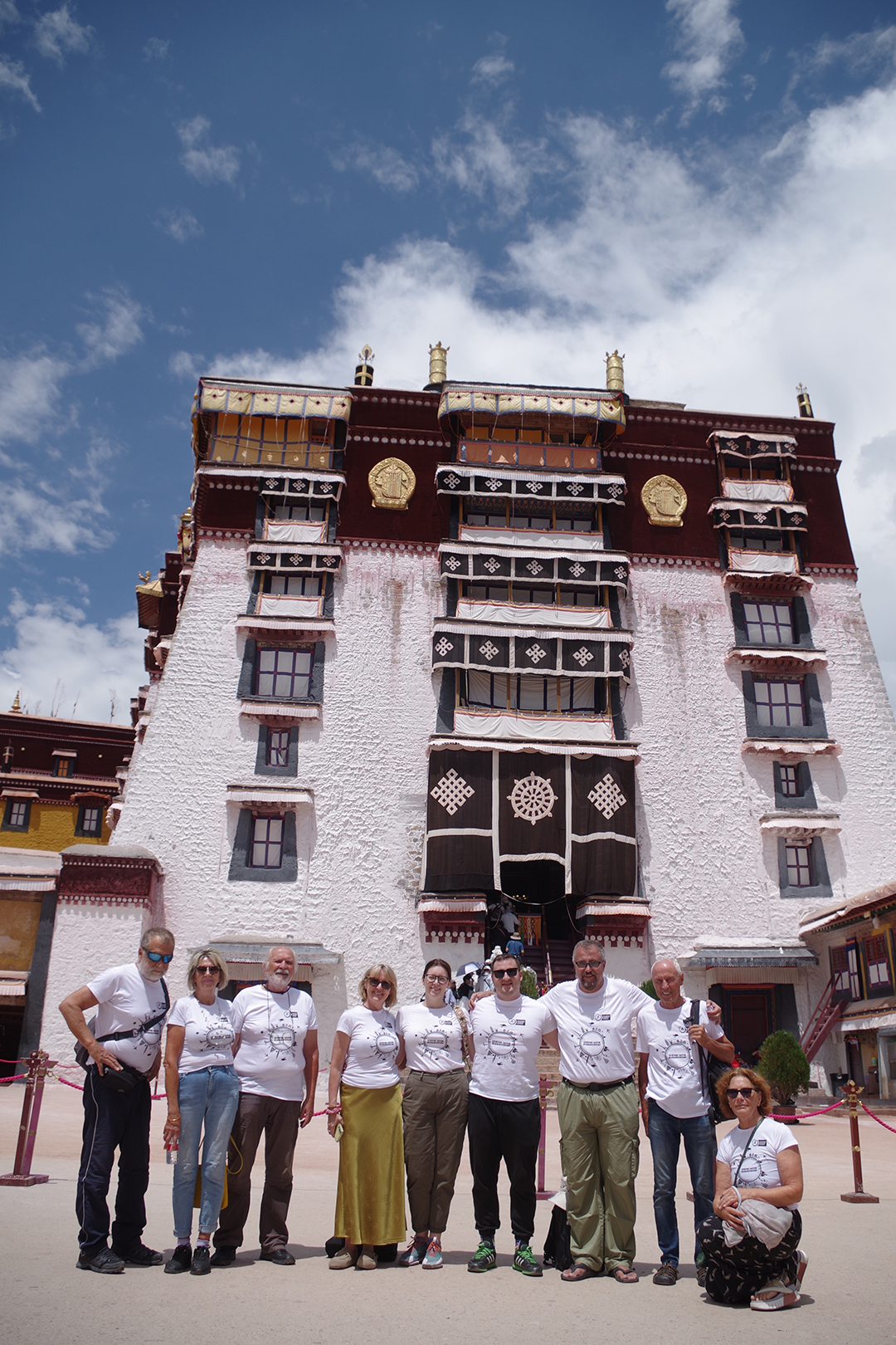 Group of travellers in front of a traditional Tibetan building within the Potala Palace complex in Lhasa.