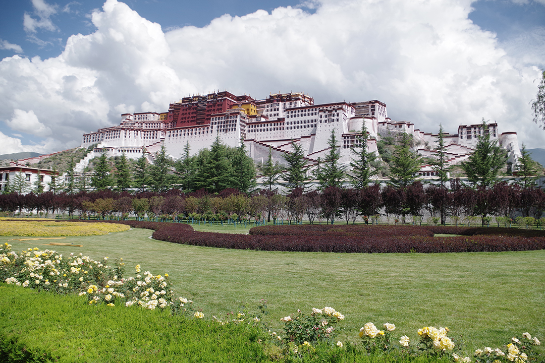 View of the impressive Potala Palace on Marpo Ri hill above a landscaped park in Lhasa, Tibet.