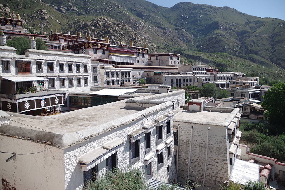 View of the white buildings of Drepung Monastery spreading across the mountain slope above Lhasa.
