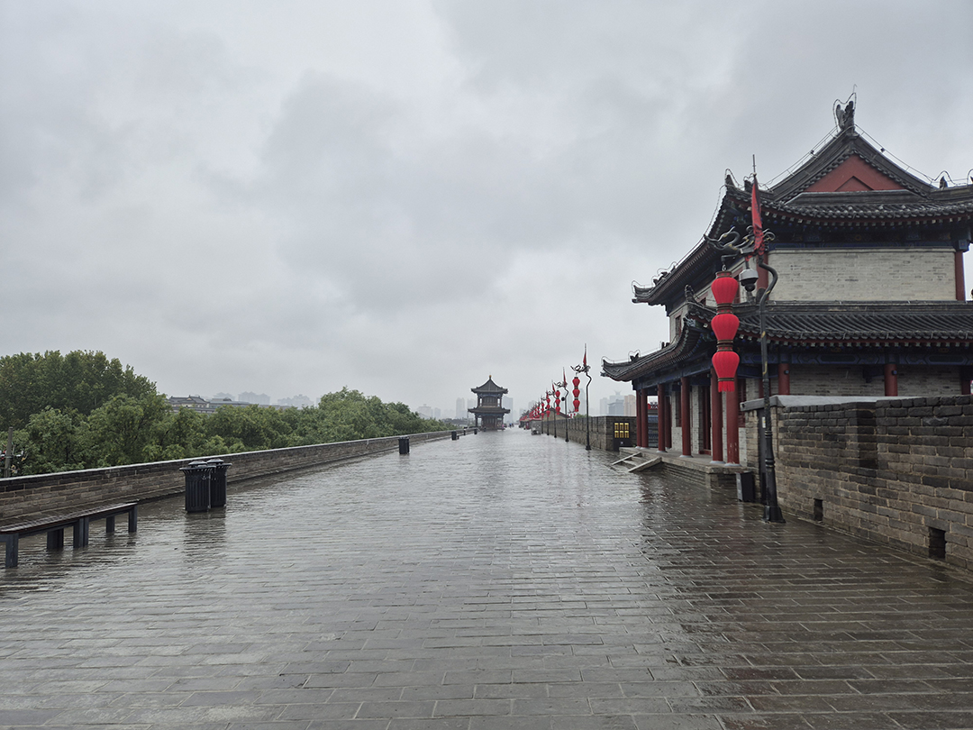 Historic Xian City Wall with traditional watchtowers on a rainy day.