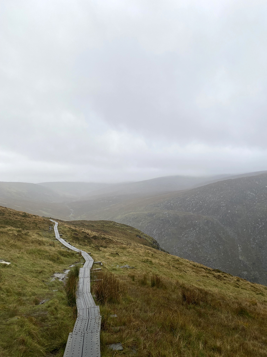 Lesena pohodniška pot skozi megleno pokrajino gorovja Wicklow