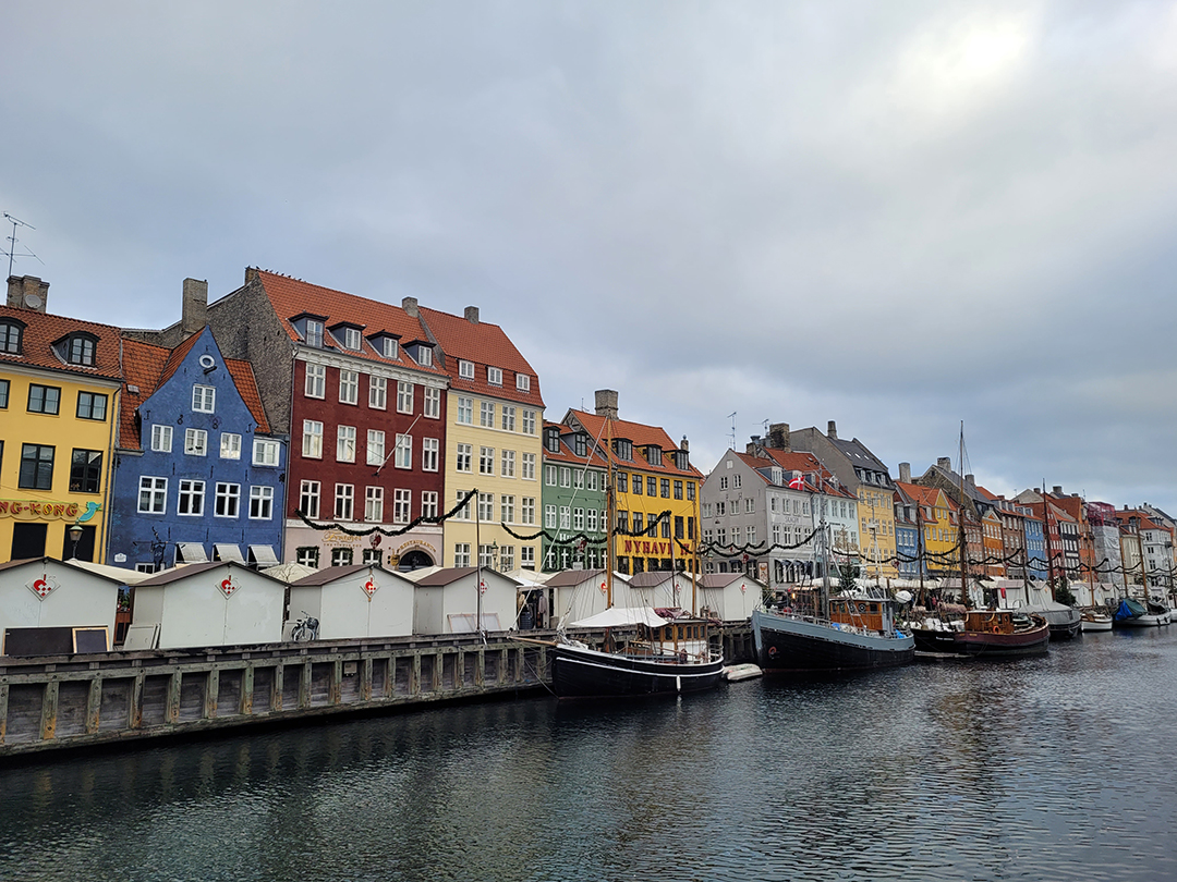 Pisane zgodovinske hiše in privezane ladje ob kanalu Nyhavn v Kopenhagnu na Danskem